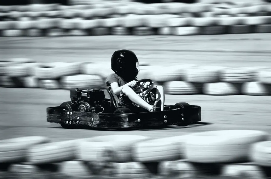 Kart em alta velocidade com o fundo de pneus borrado pelo movimento.
