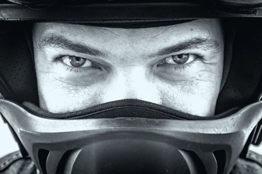 Olhos de um piloto pela abertura do capacete, em close.